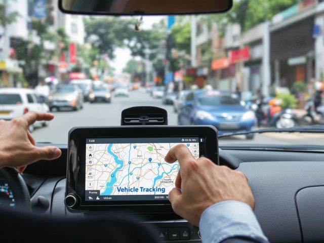 Fleet operator uses GPS tracking device in car dashboard on a city street